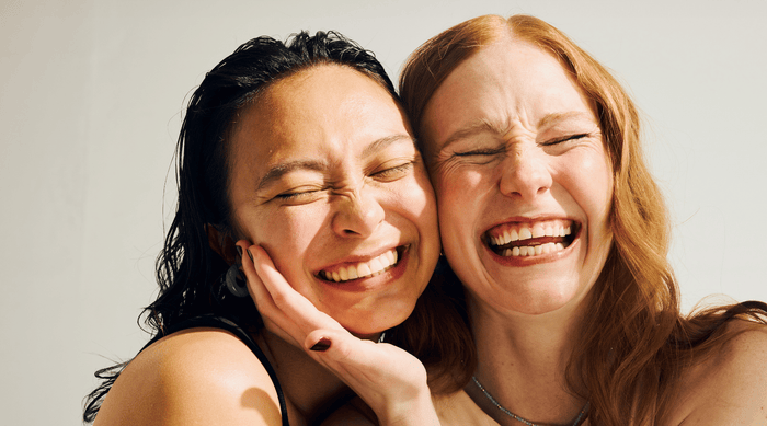 Smiling women with clear skin who understand skin health.
