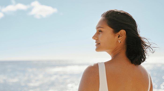 Woman looking across the ocean skyline